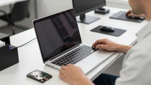 Kỹ thuật viên tháo nắp lưng laptop cũ để nâng cấp ổ SSD